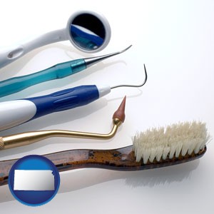 a toothbrush, dental picks, and a mouth mirror - with Kansas icon