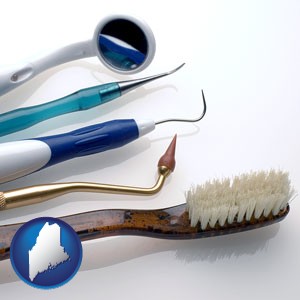 a toothbrush, dental picks, and a mouth mirror - with Maine icon