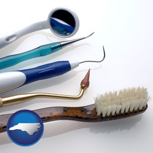 a toothbrush, dental picks, and a mouth mirror - with North Carolina icon