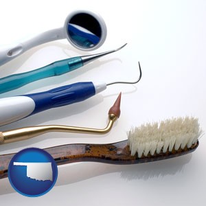 a toothbrush, dental picks, and a mouth mirror - with Oklahoma icon